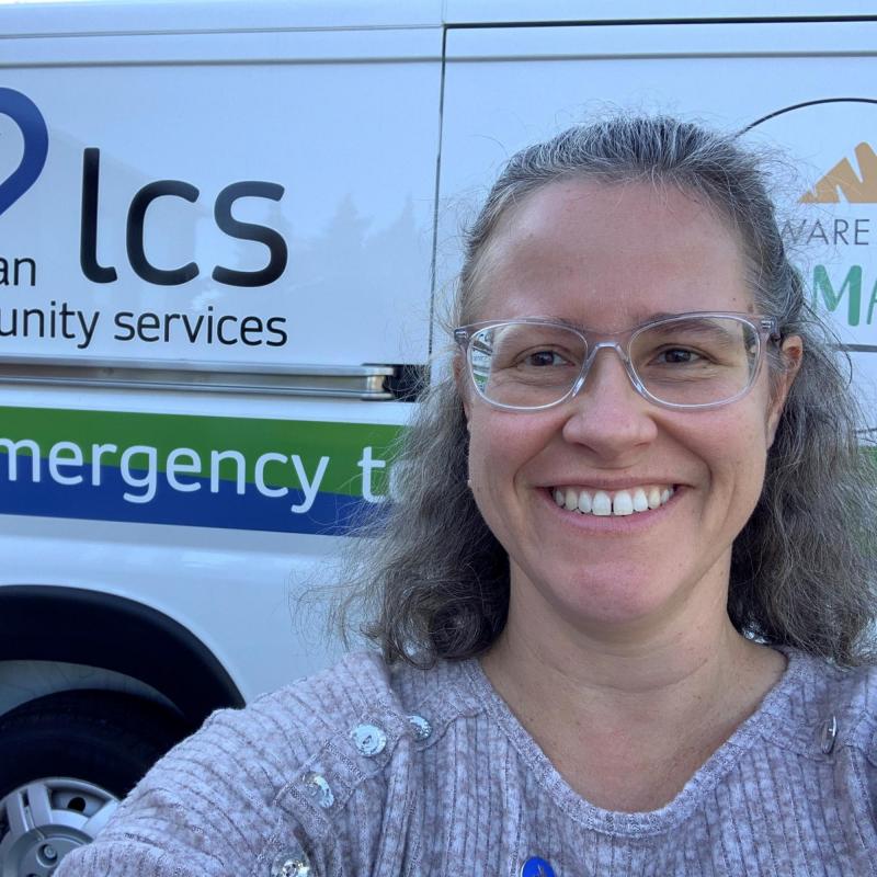 Jenn Ruebush smiling in a selfie in front of Lutheran Community Services van.