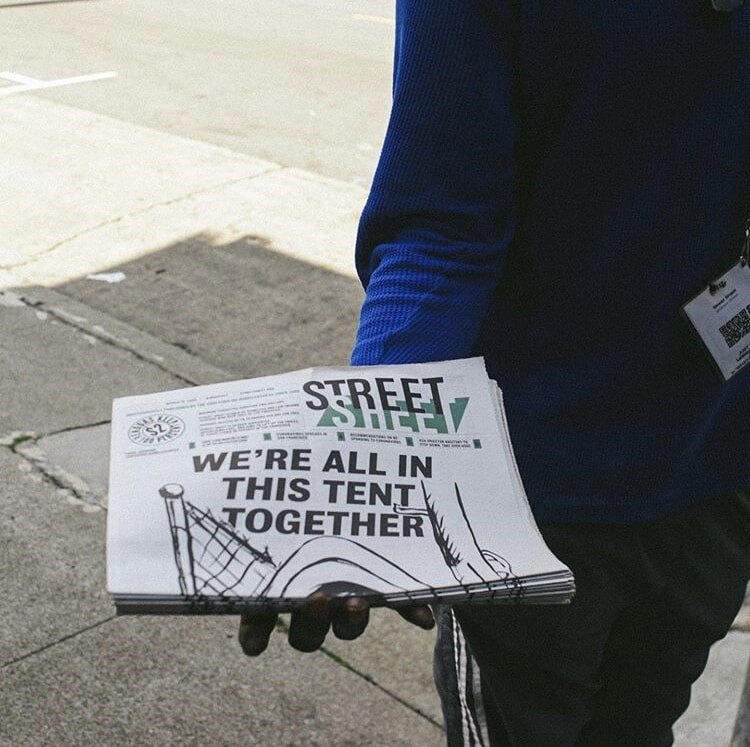 Person holding a copy of Street Sheet publication