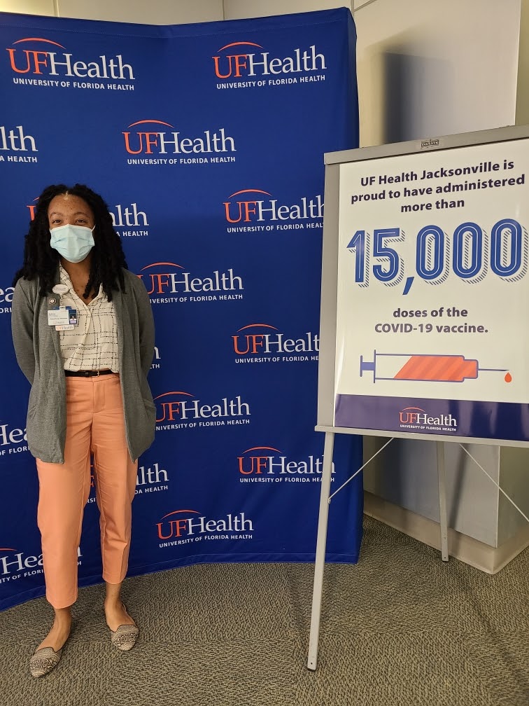 Sydney standing in front of a blue UF Health backdrop at COVID-19 vaccine districution
