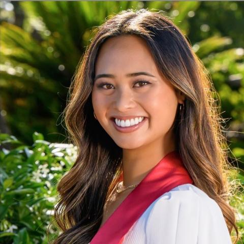 Laurel Wong is facing the camera and smiling. She is wearing graduation regalia.