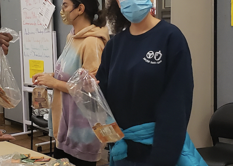 Leora packing food in bags.