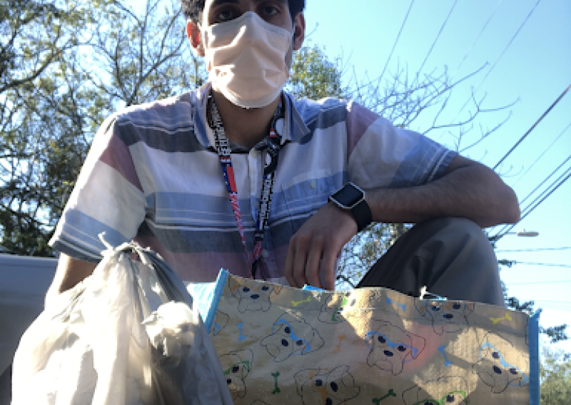 Armaan with a Thanksgiving basket and turkey that he is about to deliver to a client.