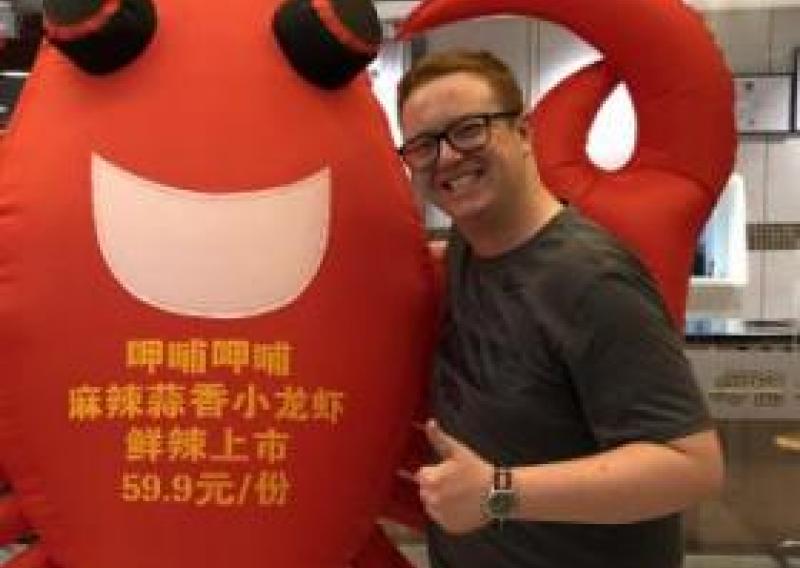 NHC PGH member Daniel smiling and thumbs up next to lobster mascot