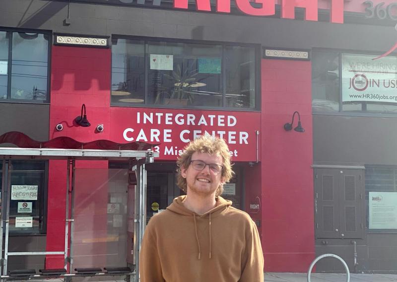 Will stands in front of the entrance to HealthRIGHT 360's Integrated Care Center.
