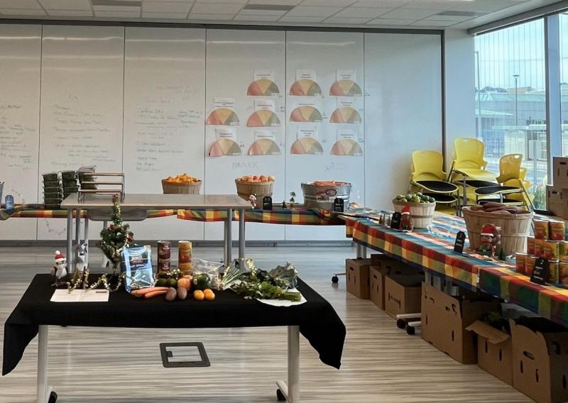 A Photo of the Food Pharmacy set up can be seen here. This includes tables in "U" formation with a variety of produce and ingredients, as well as a central table that shows a selection of what is available on that day. 