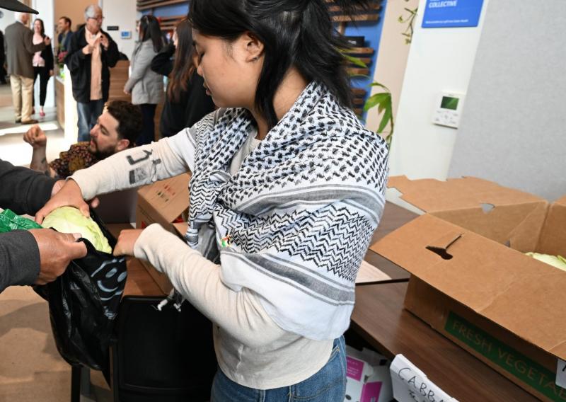 Here Natalie is seen handing a client a cabbage during food distribution. Client has been cropped out for privacy. 