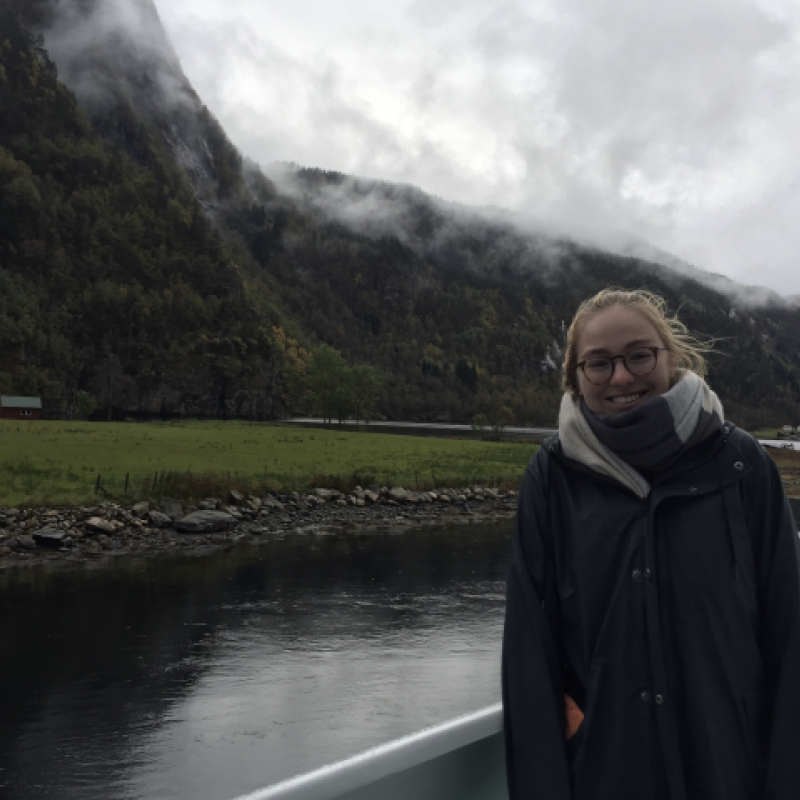 NHC PGH member Bethany smiling on a boat with mountains and water in the background