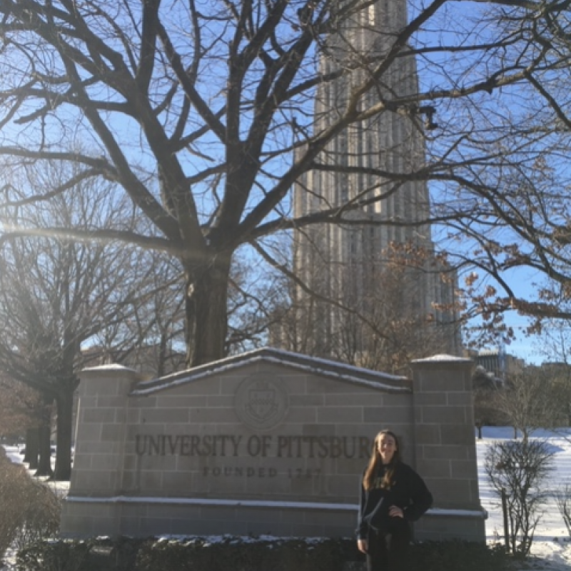 NHC PGH member Mary Margaret standing in front of a University of Pittsburgh sign