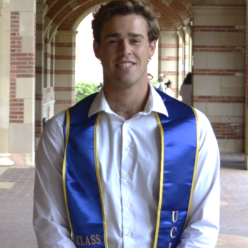 August smiling with blue graduation collar on