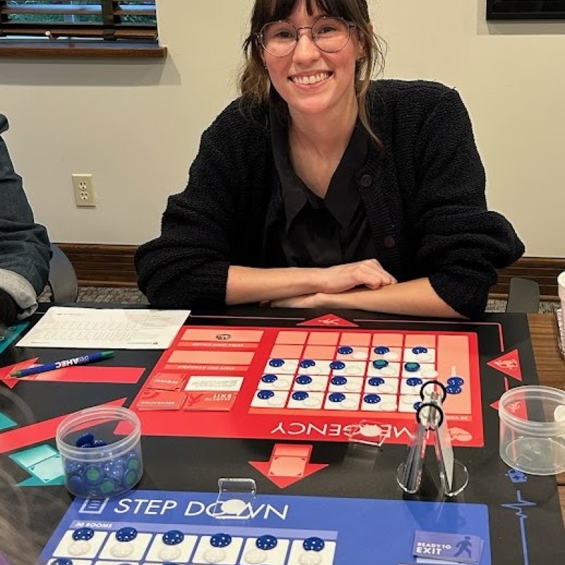 Elsa Romero is pictured sitting in front of the game board.