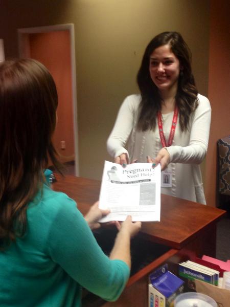 NFHC member, Katie, passing out a flyer at an organization