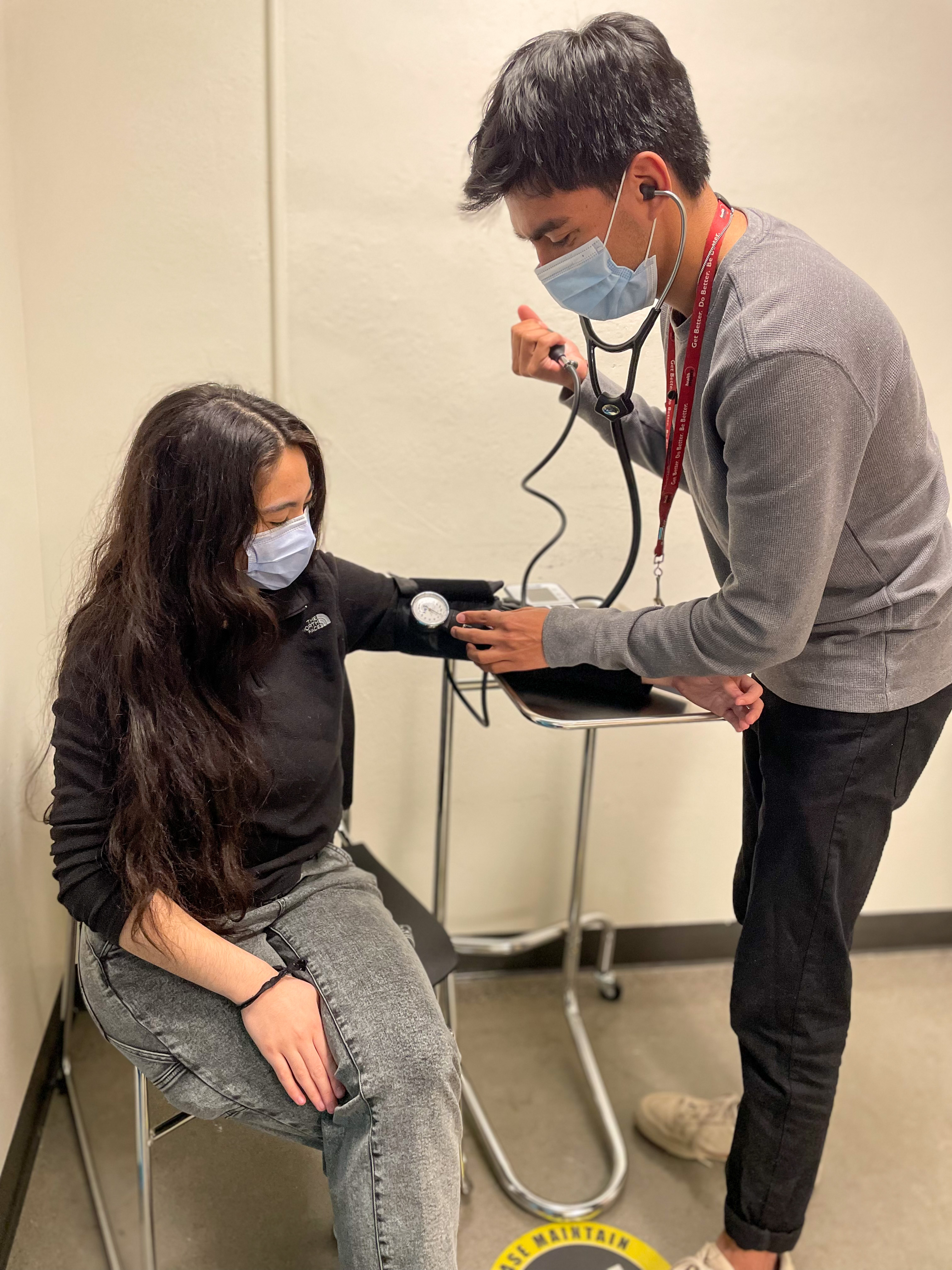 Johnny is seen practicing taking biometrics on one of the Medical Assistants at HealthRIGHT 360. 